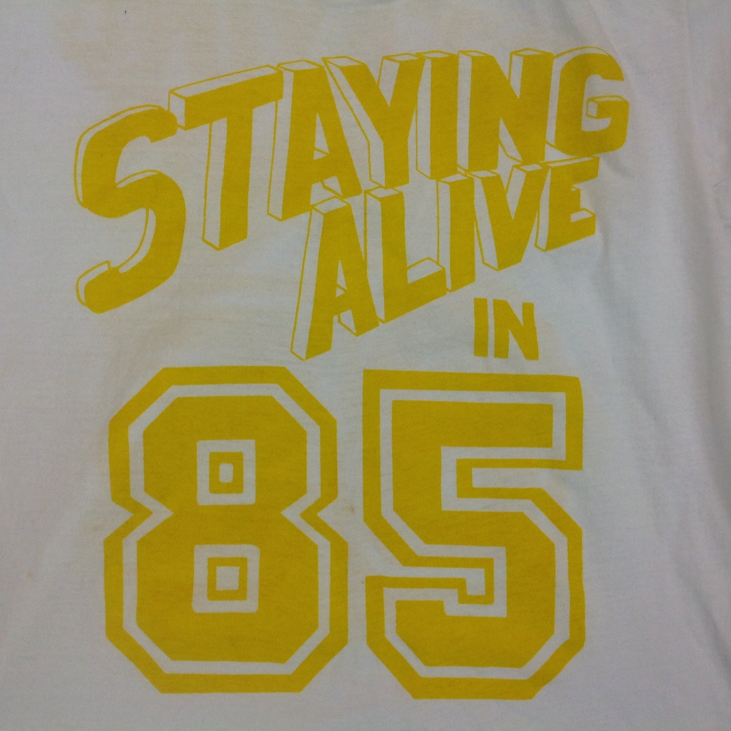 Vintage 1980's Novelty T-Shirt STAYING ALIVE IN 85 Yellow on White Katharine Hamnett