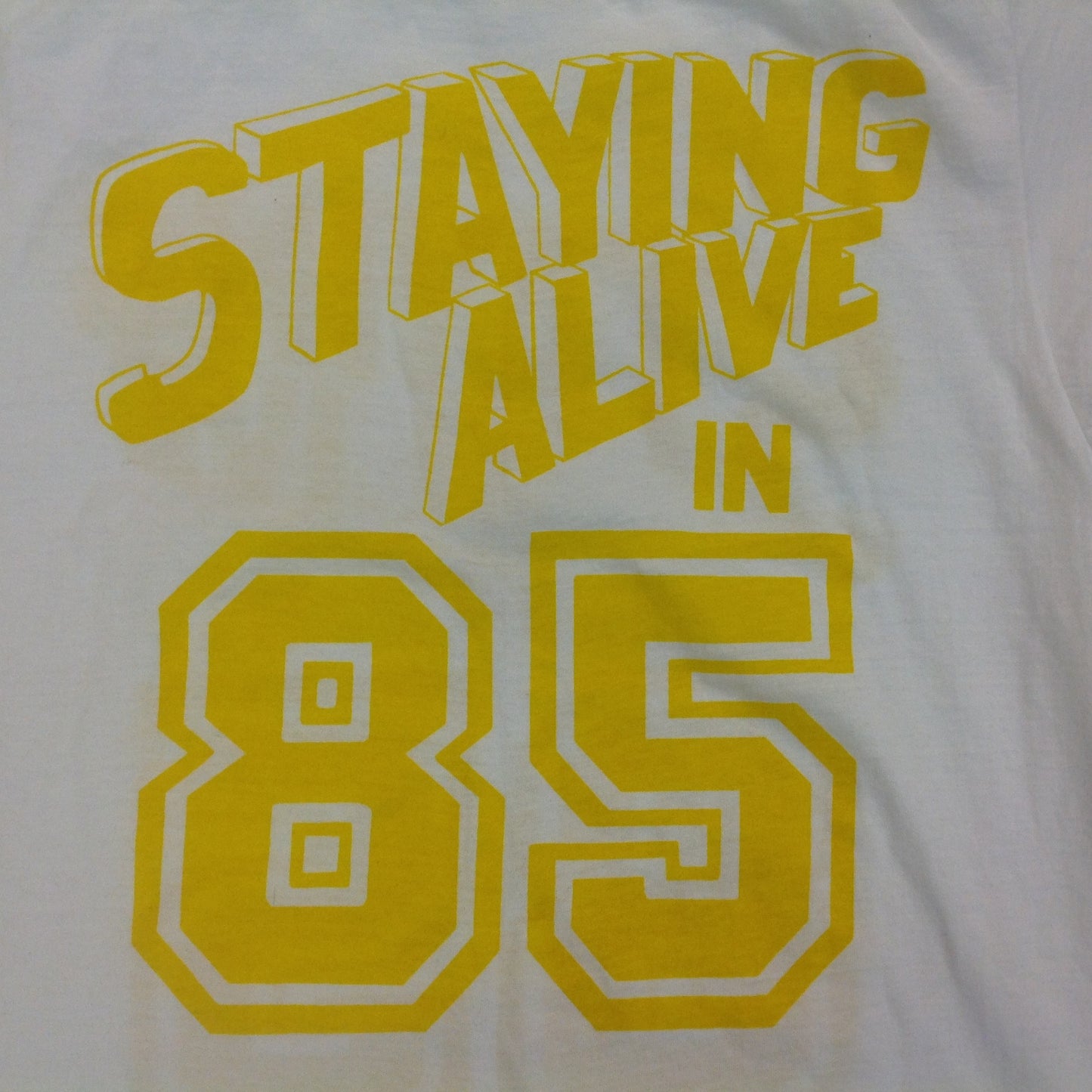 Vintage 1980's Novelty T-Shirt STAYING ALIVE IN 85 Yellow on White Katharine Hamnett